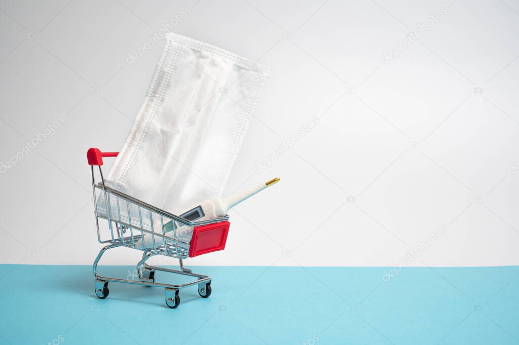 There are medical masks and thermometer in the mini shopping cart