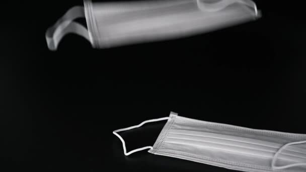 スローモーション 黒を背景にした医療用使い捨てマスク — ストック動画