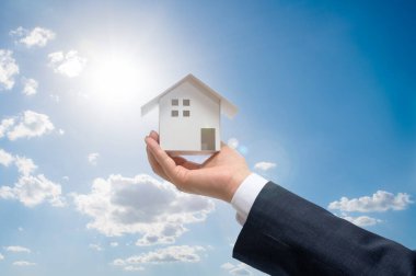 Elinde ev modeli olan bir iş adamı. Emlak kavramı