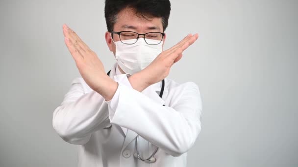 スローモーション 中年のアジア人医師が手を挙げて彼の不承認を表明します — ストック動画