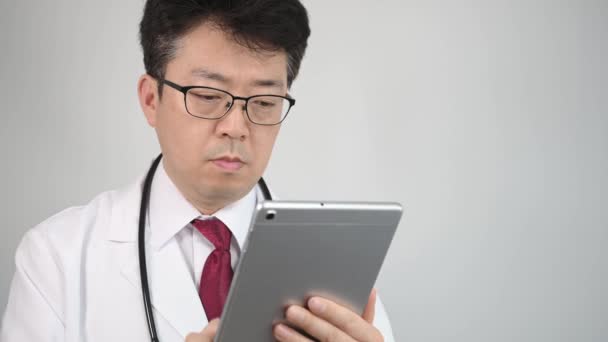 Médico Asiático Meia Idade Que Usa Computador Tablet Para Tomar — Vídeo de Stock