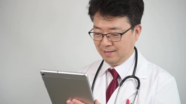 Asiatischer Arzt Mittleren Alters Der Mit Einem Tablet Computer Telemedizin — Stockvideo