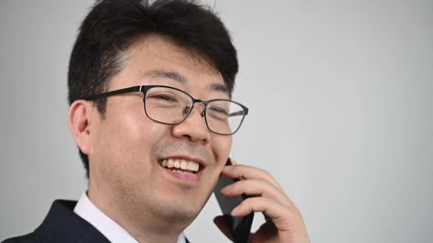 Азиатский Бизнесмен Улыбается Разговаривает Телефону Смартфоном — стоковое видео