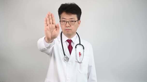 Médico Asiático Mediana Edad Levanta Mano Expresa Desaprobación — Vídeos de Stock