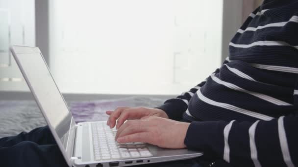 Asiatischer Mann mittleren Alters telefoniert von zu Hause aus mit einem Laptop. — Stockvideo