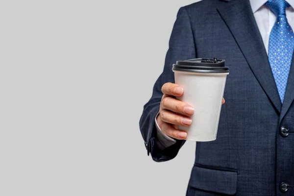 Ein Geschäftsmann hält einen weißen Pappbecher in der Hand. Mit Kopierraum. — Stockfoto