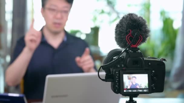 オンライン講義のコンセプト アジア系の中年男性が自宅でオンライン講義を行う ぼかしの背景 — ストック動画
