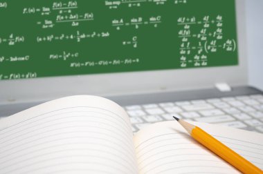 Çevrimiçi öğrenme kavramı. Dizüstü bilgisayarın klavyesinde çizgili bir defter ve sarı bir kalem var..