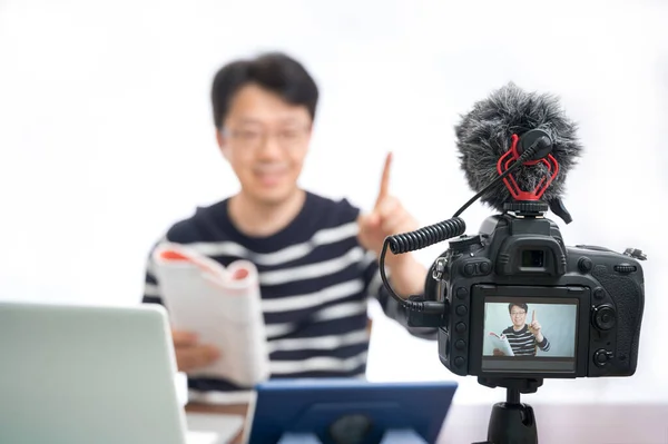 Çevrimiçi öğrenme kavramı. İnternette öğrenmeye hazırlanan Asyalı orta yaşlı bir erkek öğretmen. Bulanık arkaplan.