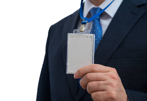 Businessman in suit wearing a blank ID tag or name card on a lanyard at an exhibition or conference.