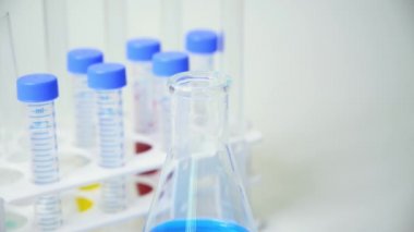 Bir araştırmacının elinde mavi sıvı içeren bir test tüpü var..