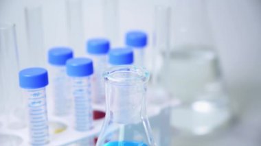 Bir araştırmacının elinde mavi sıvı içeren bir test tüpü var..
