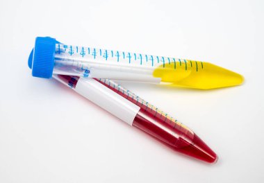 Kırmızı sıvı içeren santrifüj tüpü tutan araştırmacının elleri..