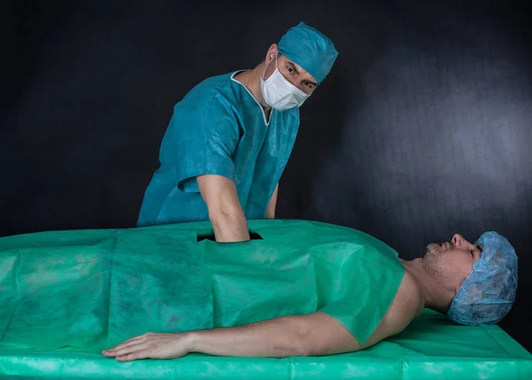 Grappige chirurgie bewerking op een zwarte achtergrond. Surgeon's hand is — Stockfoto