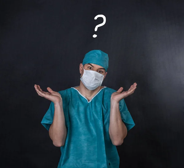 Chirurg in scrubs met een ik weet niet gebaar. Zwarte achtergrond — Stockfoto