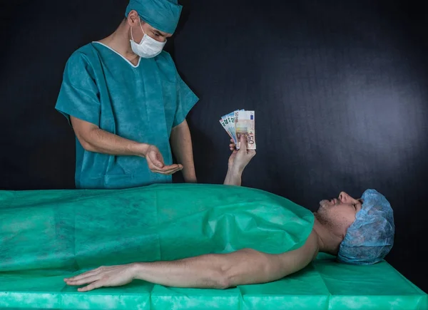 Χειρουργός λαμβάνει χρήματα από ασθενή. Μαύρο φόντο. — Φωτογραφία Αρχείου
