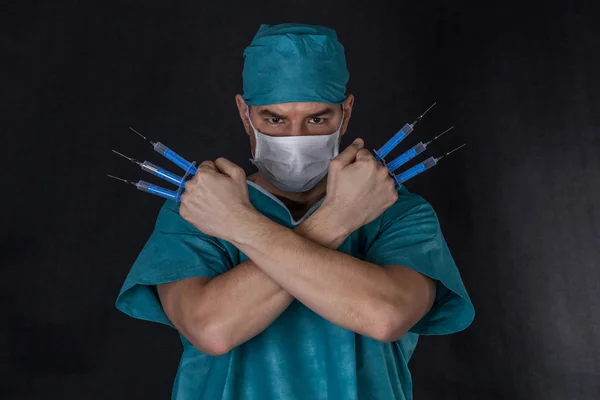 Chirurg in scrubs met spuiten armen gekruist op een zwarte CHTERGRO — Stockfoto