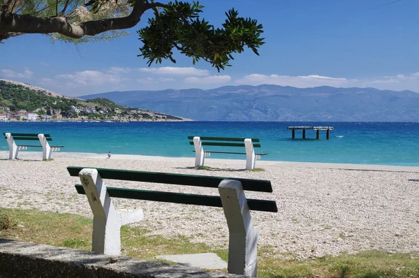 Panchine deserte sulla spiaggia di Baska, isola di Krk, Croazia — Foto Stock