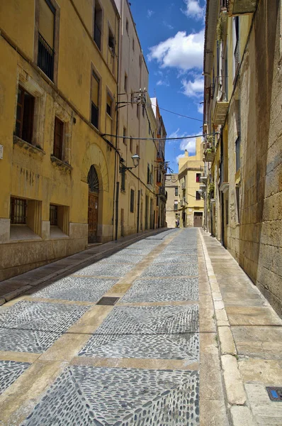 Rua deserta da velha cidade europeia num dia ensolarado. As paredes brilhantes da cidade velha de Tarragona, na Catalunha . — Fotografia de Stock