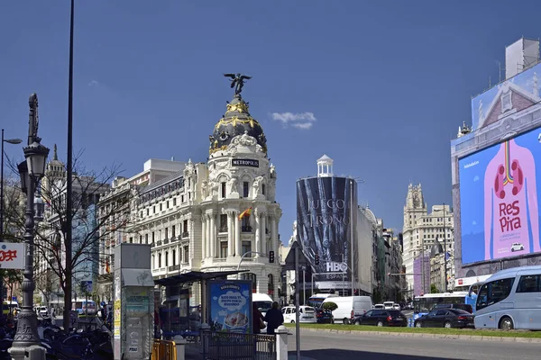 MADRID / SPAIN - APRIL 12, 2019 - Metropolis, one of the most beautiful buildings in the Calle de Alcala street with traffic jam in Madrid, Spain — Stock Photo, Image