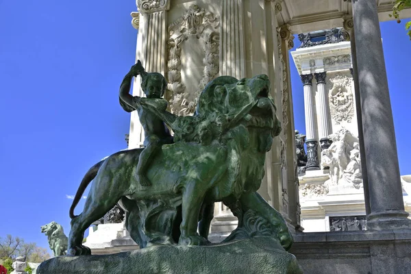 The statue of a small child riding a lion in the public Garden of Buen Retiro (The Jardines del Buen Retiro) — Stock Photo, Image