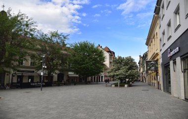 Szombath / Macaristan, 27 Nisan 2019. Öğleden sonra, Macaristan 'ın Szombath kentindeki eski şehir meydanının üzerinde mavi gökyüzü.