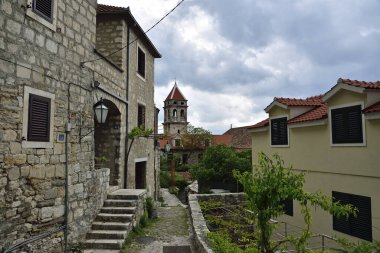 Dalmaçya, Omis, Hırvatistan ve Avrupa 'da çiçek ve bahçelerle süslenmiş Akdeniz konforlu taş kaldırım caddesi