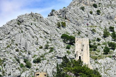 Adriyatik denizi Omis, Hırvatistan üzerindeki kayalık Dinara dağının tepesindeki eski Starigrad-Fortica Kalesi 'nin tepesine tırmanıyor