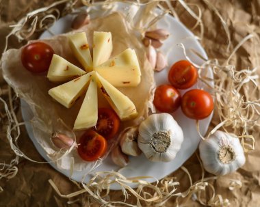 Peynir, sarımsak ve domates beyaz bir tabağa dilimlenmiş