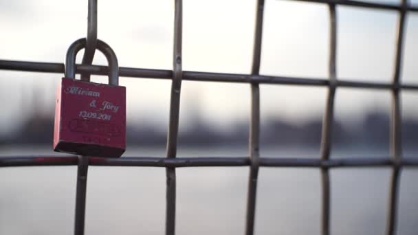A love lock hangs on a chain fence against the NYC cityscape — Stock Video