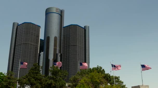 Un disparo de banderas de Estados Unidos volando fuera del centro renacentista Detroit — Vídeos de Stock