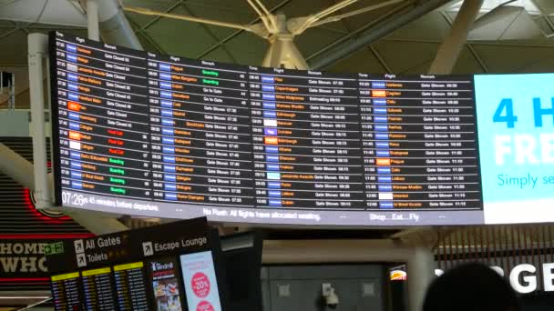 Una toma de mano de gran angular de una tabla de salida en un aeropuerto — Vídeo de stock