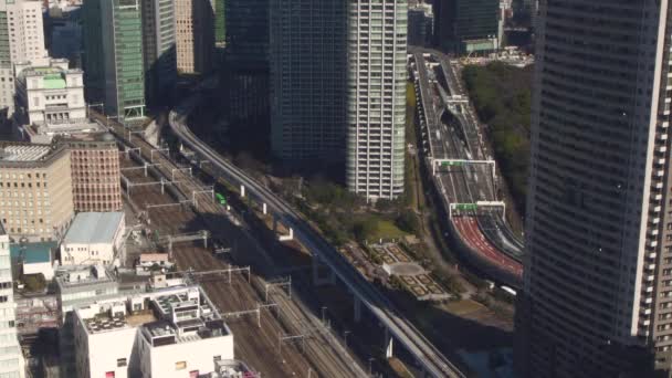 Byggnad i Tokyo som ser ner på räls och en hektisk motorvägen — Stockvideo