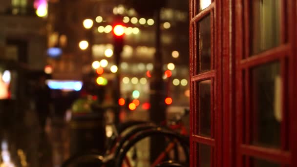 Londýn telefonní budka jako to prší na pozadí v noci — Stock video