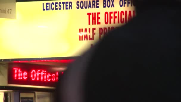 A zblízka z pokladny značky na Leicester Square, v noci osvětlená — Stock video