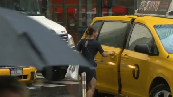 Uma foto de uma senhora entrando em um táxi na chuva em Nova York — Vídeo de Stock