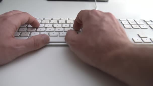Adam beyaz bir arka plan bilgisayar klavyesindeki yazarak — Stok video