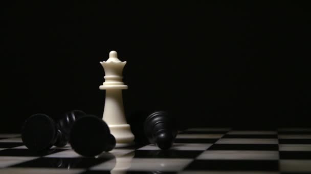 White queen surrounded by fallen black pawns — Stock Video