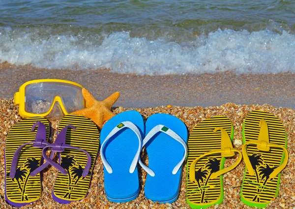 Chinelos coloridos, estrelas do mar e máscara subaquática na praia . — Fotografia de Stock