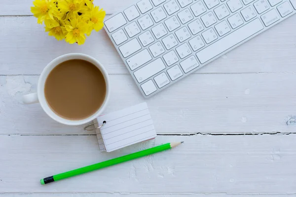 Ofis resepsiyon masası bilgisayar, sarf malzemeleri, kahve fincanı ve çiçek ile