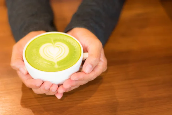 Erkek holding bardak kahve rustik ahşap masa backg üzerinde eller