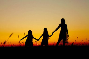 Gün batımında aile siluetleri Anne kızları
