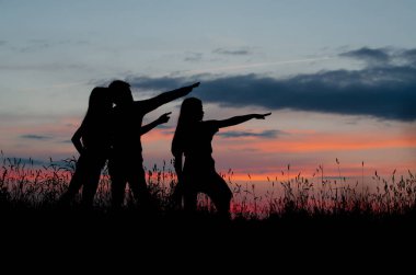 Gün batımında üç siluet göster