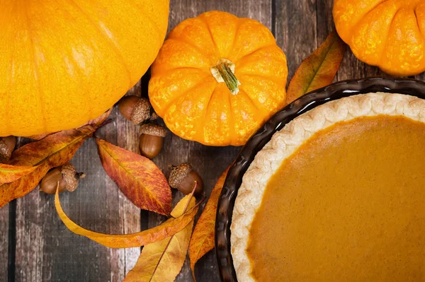 Torta di zucca con zucche e decorazioni autunnali su tavolo rustico — Foto Stock