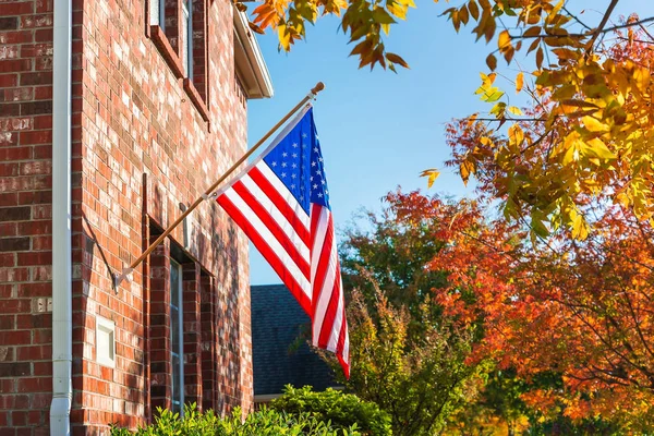 Bandera americana frente a una casa de ladrillo —  Fotos de Stock