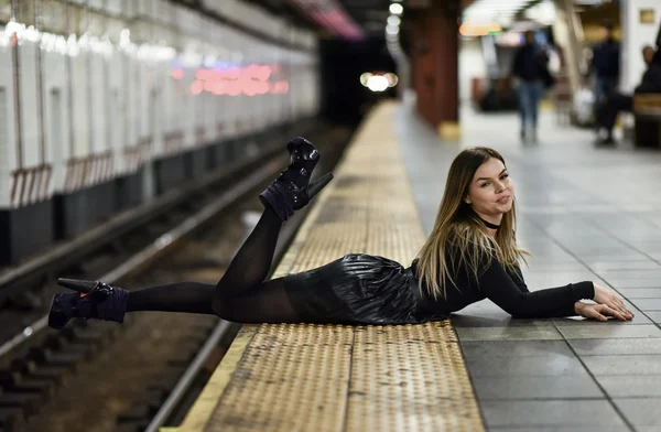 Sexig modell liggande vid kanten av tunnelbana plattform — Stockfoto