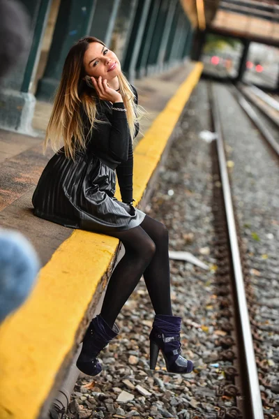 年轻漂亮的女孩坐在火车平台上 — 图库照片