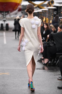 JAMAICA, NEW YORK - 06 Şubat 2020 'de DHL JFK Havalimanı' nda Jessica Minh Anhs Moda Fuarı sırasında VUNGOC ve Oğlu için podyumda bir model yürüyor 