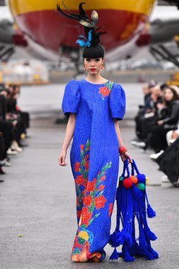 JAMAICA, NEW YORK - 06 Şubat 2020 'de DHL JFK Havalimanı' nda Jessica Minh Anhs Moda Fuarı sırasında VUNGOC ve Oğlu için podyumda bir model yürüyor 
