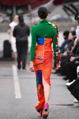 JAMAICA, NEW YORK - 06 Şubat 2020 'de DHL JFK Havalimanı' nda Jessica Minh Anhs Moda Fuarı sırasında VUNGOC ve Oğlu için podyumda bir model yürüyor 